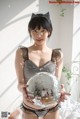 A woman in lingerie holding a disco ball.