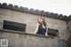 A woman in a black dress standing on a ledge.