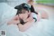 A woman laying on top of a bed with a cat ears headband.