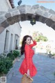 A woman in a red polka dot dress is posing for a picture.