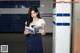 A woman in a school uniform reading a book.