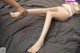 A woman laying on top of a bed next to a doll.