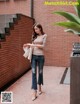 a woman standing in front of a brick wall