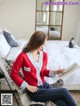 A woman sitting on a chair reading a book.