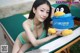 A woman in a green bikini holding a stuffed penguin.