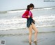 A woman standing in the water at the beach.