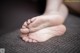 A close up of a person's bare feet on a couch.