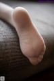 A close up of a person's foot on a couch.