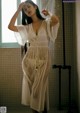 A woman standing in a bathroom next to a shower.