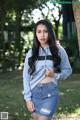 A woman in a denim skirt and a hoodie posing for a picture.