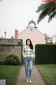 A woman standing in front of a pink building.