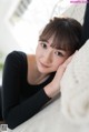 A woman laying on top of a white couch.