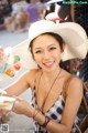 A woman in a white hat holding a bag of candy.