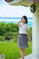 A woman standing on a porch next to the ocean.