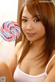 A woman holding a lollipop in her hand. 