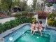 A group of women in bikinis sitting in a swimming pool.