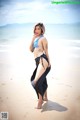 A woman in a bikini standing on a beach.