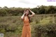 A woman in a polka dot dress standing in a field.