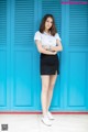 A woman standing in front of a blue door.