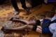 A woman laying on the floor with a gun in her hand.