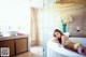 A woman laying in a bathtub in a bathroom.