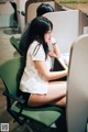 A woman sitting at a desk in front of a computer.