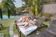 A group of women laying on lounge chairs next to a swimming pool.